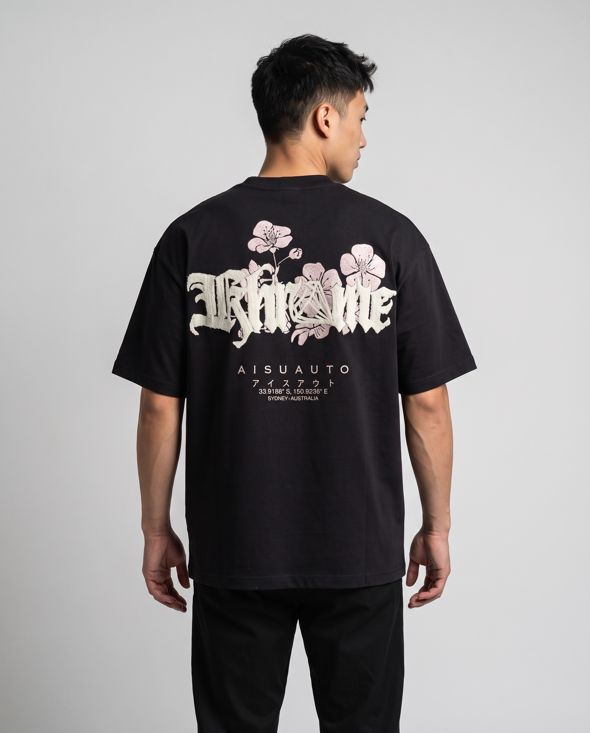 Black Sakurasheniru Blossom T-Shirt by KHROME AISUAUTO worn by a model, back view showing the full back print