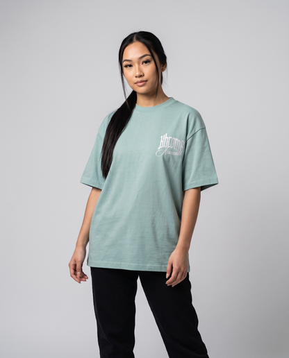 Teal Minimarisuto Sakura T-Shirt by KHROME AISUAUTO worn by a model, front view with chest logo