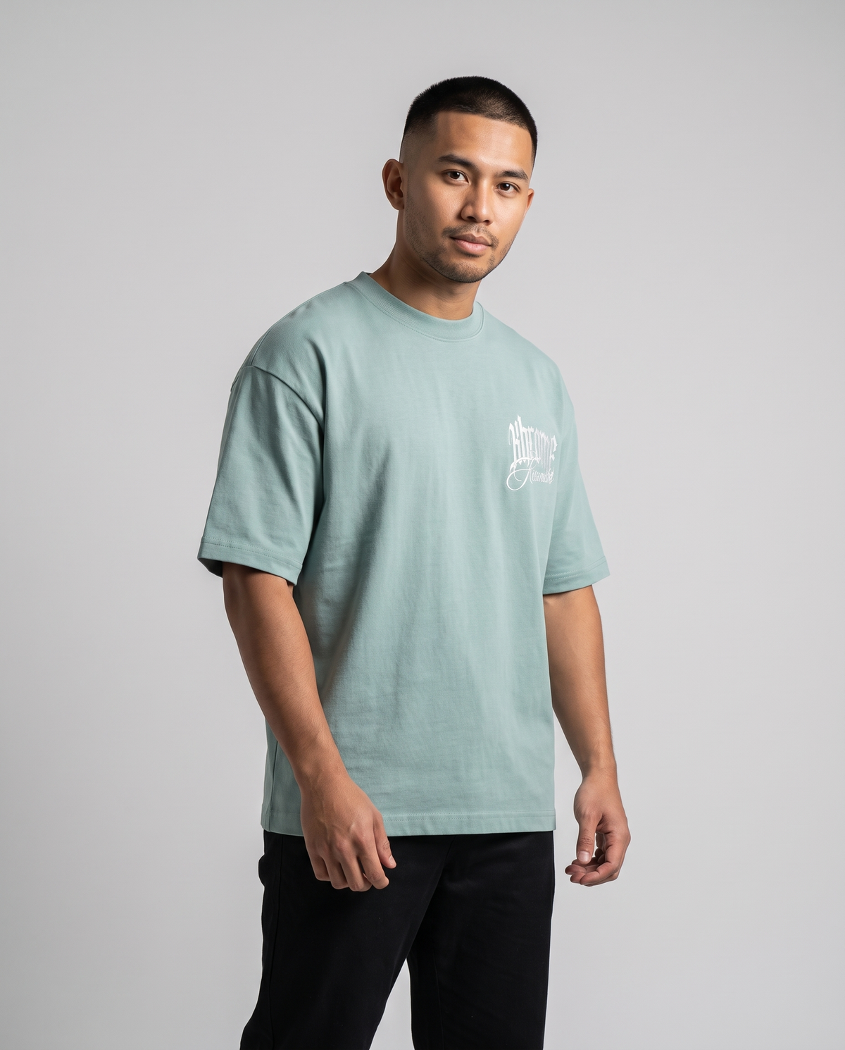 Teal Minimarisuto T-Shirt by KHROME AISUAUTO worn by a model, front view with chest logo